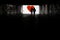 Silhouette of a man in a dark tonel against a background of a large red heart. Love, loneliness, conceptual photo.