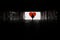 Silhouette of a man in a dark tonel against a background of a large red heart. Love, loneliness, conceptual photo.
