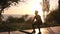 Silhouette of a man doing arm exercises and squats outdoors using resistance band outdoors in nature. Triceps and legs