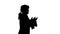 Silhouette Man dressed as courtier talking expressively and waiving his hands while walking and looking at camera.