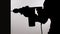 Silhouette of a man drilling a wall