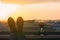 Silhouette of man feet with glass of red wine on the balcony on the city background