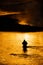 Silhouette of Man Flyfishing in River