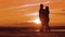 Silhouette man and girl of a happy young married couple slow dancing outside at sunset. Couple enjoying on nature the