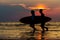 Silhouette Of man and girl surfers running to the sea with surf