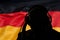 Silhouette of a man in headphones on the background of the flag of Germany, eavesdropping conversation, secret agent, military.