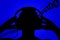 Silhouette of man with headphones on blue background, absorbing information