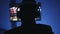 Silhouette of man in headphones playing interesting video game at home at night