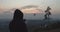 Silhouette of a man launching a quadcopter into the sky