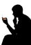 Silhouette of a man looking at an alcoholic drink