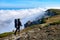 Silhouette of a man in the mountains. Successfully achieving goals. Male hiker on mountain peak with green grass looking