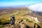 Silhouette of a man in the mountains. Successfully achieving goals. Male hiker on mountain peak with green grass looking