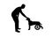 Silhouette Man outdoors strokes his paralyzed dog in a wheelchair.