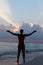 Silhouette Of Man With Outstretched Arms On Beach