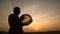 Silhouette of man plays the drum in sun set