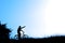 Silhouette of a man raising hand on bicycle on blue sky