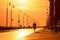 Silhouette of a man running on a boardwalk at sunset. Long Beach NY