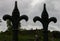 Silhouette of man sitting on bench on a hill viewed through cemetery