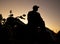 Silhouette of man sitting on motorcycle at dusk