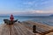 Silhouette of man sitting on snag on lake berth and watcing the sunset on lake Baikal