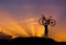 Silhouette the man stand in action lifting bicycle above his head with sunset