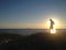 Silhouette of a man standing against the sunset, ocean, outdoors, mysterious