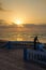 Silhouette of man standing at beach promenade with stone walkway during sunset at Sidi Ifni, Morocco, North Africa
