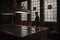 Silhouette of man standing by a grand table in an old house. Leaded windows letting in light from behind him.