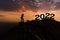 Silhouette Man standing on mountain and number 2022 , Happy New Year 2022 and Merry Christmas Concept.