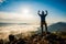 Silhouette man standing on top of the mountain watching the sun rise with fog