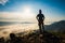 Silhouette man standing on top of the mountain watching the sun rise with fog