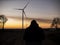 Silhouette of a man at sunset making a photo of wind turbines.wind power plants at sunset