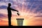 Silhouette of a man throws a crown in the garbage bin