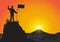 Silhouette of man on top of mountain holding flag on golden sunrise background, success, achievement and winning concept