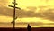 Silhouette man on top of the mountain looking with hope at the Christian Cross. A man making a confession to the cross, background