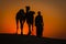 Silhouette of man and two camels at sunset in Thar desert near Jaisalmer, Rajasthan, India