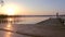 Silhouette of man walking along the pier in the lake until sunrise.