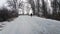 Silhouette of a man walking in the distance on a forest road in winter. There is a lot of snow. A lonely boy walks along a path in