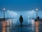 silhouette of a man walking on a foggy street at night