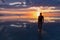 Silhouette of man walking into the sunrise of lake Bonneville Salt Flats, Wendover, Western Utah, USA, America. Dreamy red colored