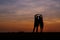 Silhouette man and woman with beautiful the sky at sunset.Backg