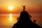 Silhouette of a mans on a mountain top on sunset background.