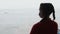 Silhouette of a Masked Young Woman at Airport Terminal Window Looking at Planes