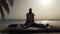 Silhouette of masseur doing thai yoga massage for a woman at sunrise outside.