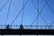 Silhouette of mature cyclists on a bridge