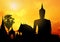 silhouette meditation Buddha with sunlight on sky background,church pagoda and bell