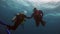 Silhouette of men and girls scuba divers underwater in Galapagos.