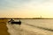 Silhouette of men pulling a boat into the sea at a beach in Gujarat