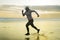 Silhouette of middle aged woman running on the beach - 40s or 50s attractive mature lady doing jogging workout enjoying fitness