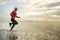 Silhouette of middle aged woman running on the beach - 40s or 50s attractive mature lady doing jogging workout enjoying fitness